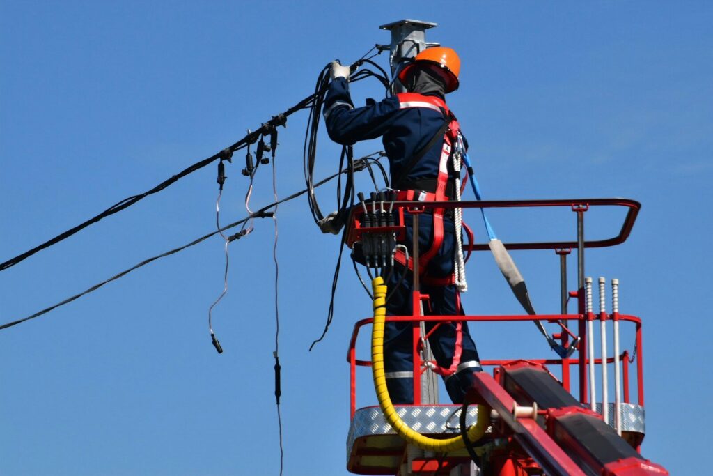 Un homme réparant les lignes électrique après une tempête