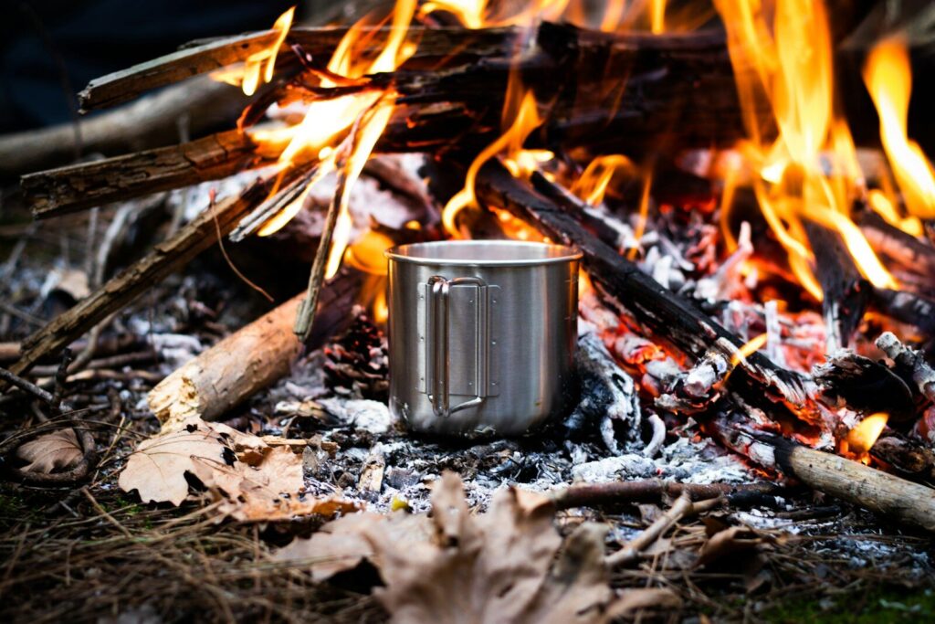 Eau portée à ébullition sur feu de camp — purification eau forêt sans matériel