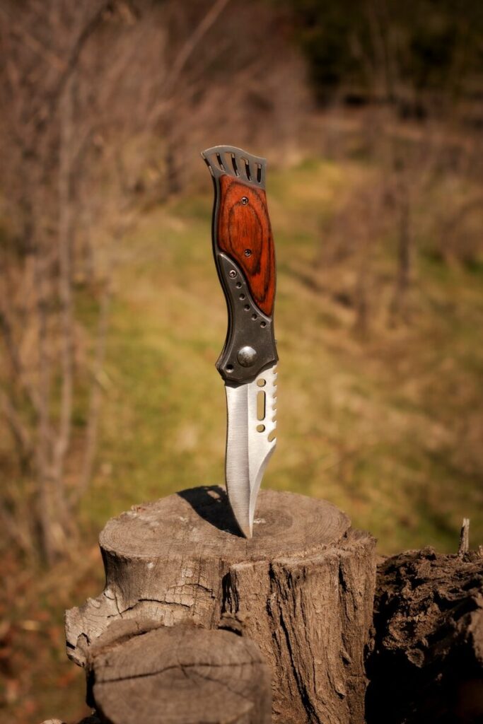 Meilleur couteau de survie moins de 1000 euros - Couteau artisanal manche bois posé sur établi d'atelier
