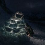 Abri de survie hivernal en forêt enneigée