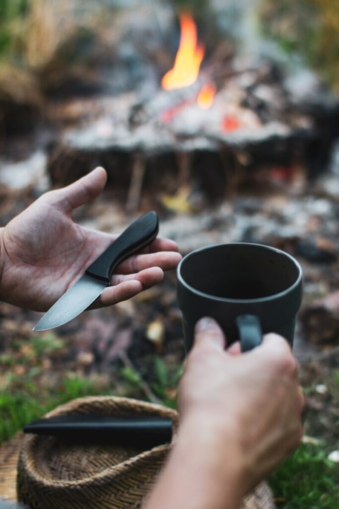 Couteau de survie proche d'un feu de camp en plein air